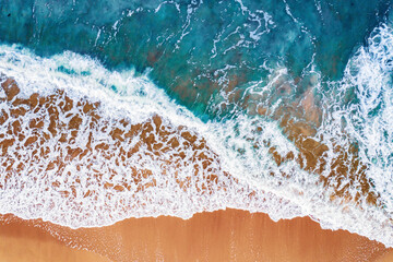 Türkisfarbenes Wasser mit Welle mit Sandstrand Hintergrund aus der Luft von oben. Sonniges Reisebild des Konzeptsommers