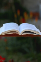 Open book in a garden. Selective focus.