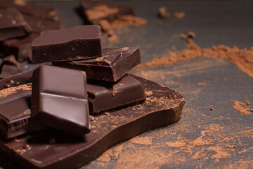 Chocolate with cocoa close up powder on grey background