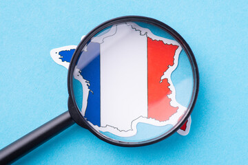 Magnifying glass over a map of France. Concept of geography, traveling, studying the country,...