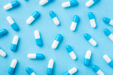 Background of many blue and white pills on a blue medical background. Concept of medicine,...