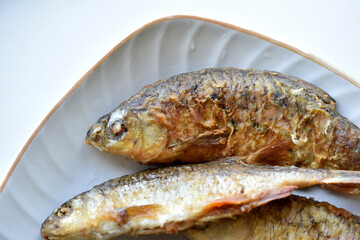 Freshly fried river fish in a plate in the kitchen