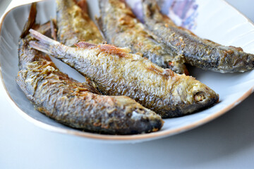Freshly fried river fish in a plate in the kitchen