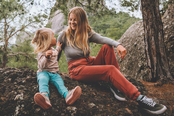 Mother and daughter child outdoor family lifestyle summer vacations together walking in forest...