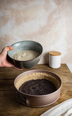 pouring cheesecake batter on a pie crust