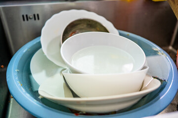 Used dishes prepared to wash on the kitchen sink