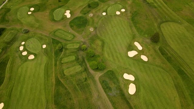 Aerial drone view of a golf course with people playing golf in 4k