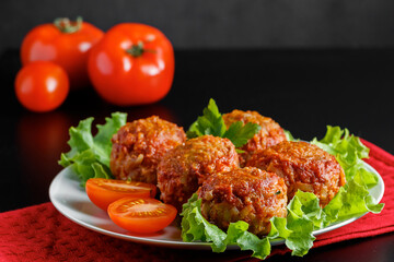 Meat balls in tomato sauce on a black background. Homemade protein meal for healthy diet.