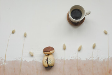 Cake mushroom and a cup of hot coffee on the table top view. Appetizing cake. Cookie and coffee