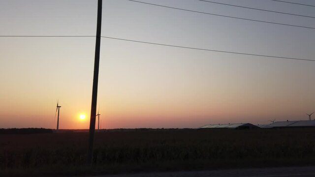 Driving Past Energy Turbines At Sunset Then Massive Greenhouses Energy Conservation