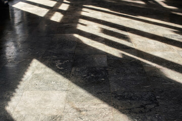 Shadows from window frames on stone indoor floor, shallow depth of field photo