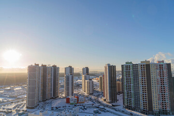The sky at dawn from a tall building. Beautiful view of the modern city with high-rise buildings on the background of the sky and the sun in the morning.