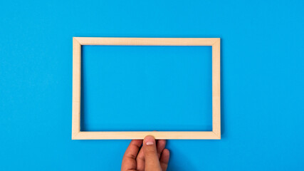Wooden frame on blue background. Minimal border composition for your design. Copy space for text.