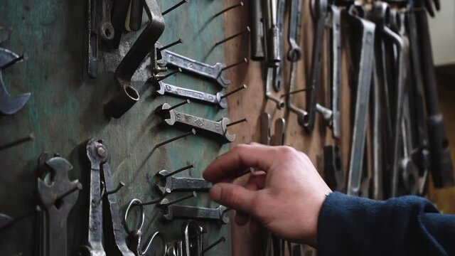 Man taking wrench from stand