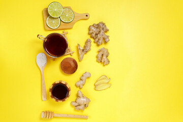 Tea with ginger lime, honey dried fruits on a yellow background. top view. Copy space