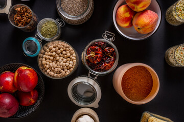 overhead image of glass jars with chickpeas, cocoa, peaches, nectarines, chia, garlic