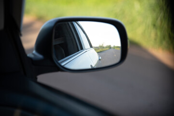 Close up of car mirror with reflection of a beautiful landscape.