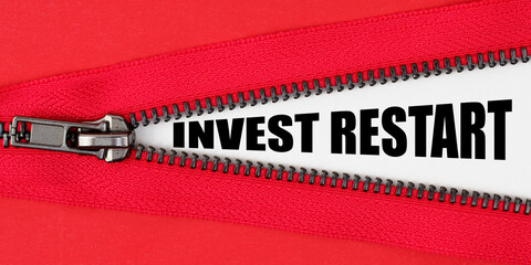 Against the background of red fabric, a zipper opens, on the white surface the inscription - INVEST...