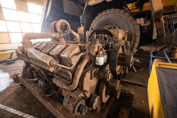 The dirty engine of a large quarry truck in the repair area