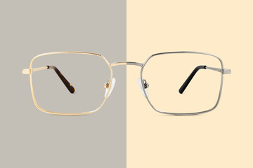 Silver and golden metal color eye glasses isolated on beige and gray background, ideal photo...