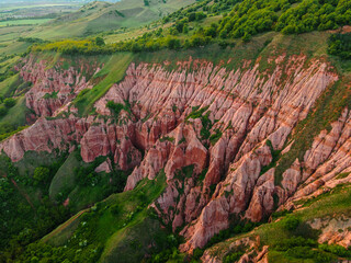 Aerial photography of the Red Ravine located in Romania, Alba county. Photo taken from a drone from a higher angle. Drone shot of a natural canyon formation  - obrazy, fototapety, plakaty