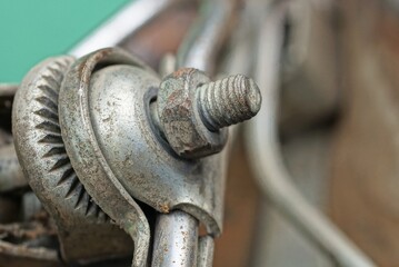 one iron nut screwed onto a bolt on a gray metal construction