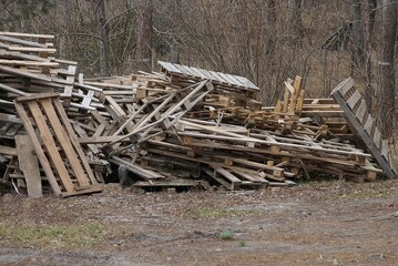 a pile of gray wooden old pallets on the ground in the street