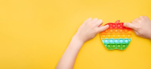 children's hands play Colorful Push pop bubble sensory anti-stress toy