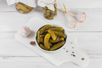 Preserving pickled cucumbers, seasonings and garlic on white wooden table