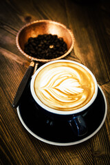 Coffee cup and beans on old vintage table. Top view with copy space for your text into the background.	
