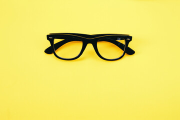 Hipster eyeglasses in black frames on a yellow background. Glasses for vision.