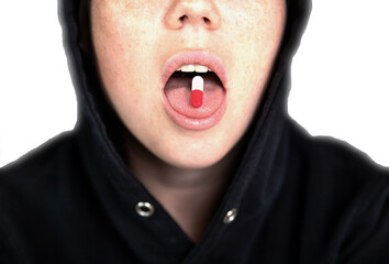 A woman is holding a pill, capsule with a drug on her tongue, teenager taking xtc.cocaine or other drugs or medicine