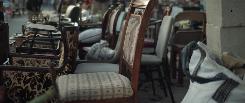 Antique retro chairs are for sale in a street flea market. Slow motion. 