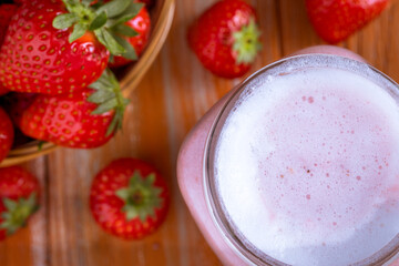Healthy pink smoothie with strawberry in glass jars.