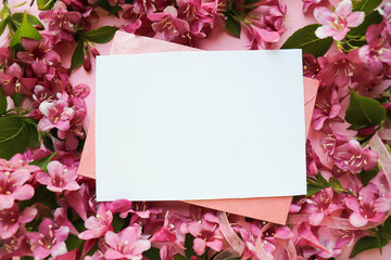 postcard mockup. floral frame made of pink flowers, envelope and white blank for the text. congratulation. invitation 