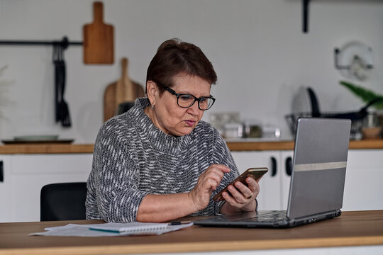 Modern Old Cheerful Lady Using Online Banking. Frustrated Senior Woman Yelling At The Bank Clerk, Dissatisfied With Her Credit Card Balance.