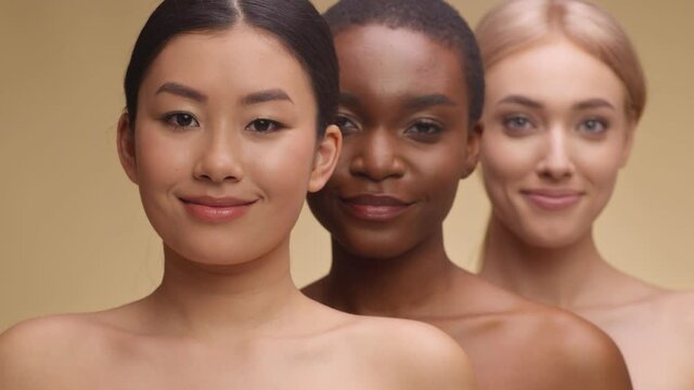 Spa and body care concept. Beauty portrait of three diverse beautiful ladies smiling to camera, standing one by one