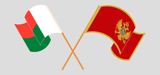 Crossed and waving flags of Madagascar and Montenegro