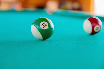 Playing with striped balls on a billiard table. Close-up.