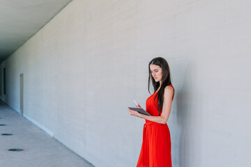 Young business woman writing in a tablet.