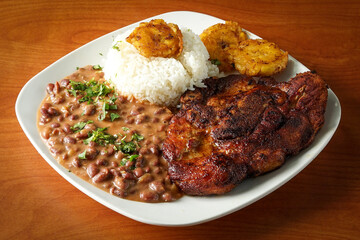 Grilled steak with bean, white rice and tostones