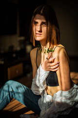 Beauty portrait of a beautiful young girl with a shadow pattern on the face and body in the form of stripes. fashion, beauty. Female clavicle of green leaves, plaster.