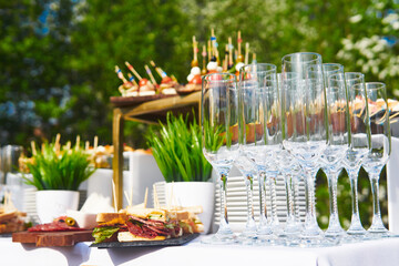 glasses, canapes and cold snacks on the table before the start of the buffet table outdoors