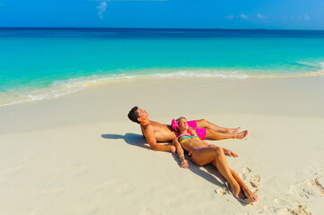 Fototapeta na wymiar Couple at the beach, relaxing, sitting on the beach 