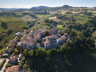 Fototapeta na wymiar Italy, May 2021. Aerial view of the medieval village of Serrungarina in the province of Pesaro and Urbino in the Marche region. You can also see the green hills around.