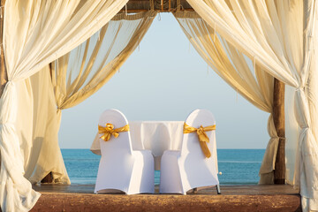 two chairs in wedding decoration in tropical tent with sea view