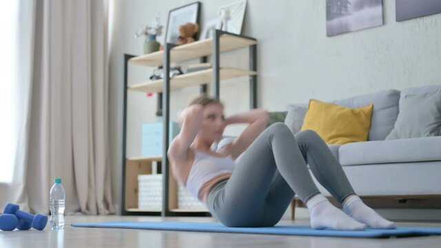 Athletic Young Woman doing Crunches Exercise on Yoga Mat