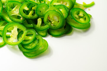 Fresh sliced green jalapeno peppers on a white background, spicy flavor ingredient in many dishes