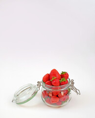 Strawberry in a jar on white background, harvesting for winter, copy space, vertical photo
