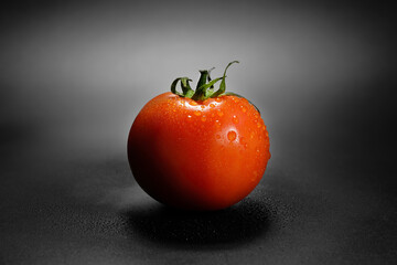 Fresh red tomato with water drops on a dark background. Natural, organic, ripe vegetables